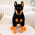 黒と茶色のドーベルマン犬のぬいぐるみが座っている