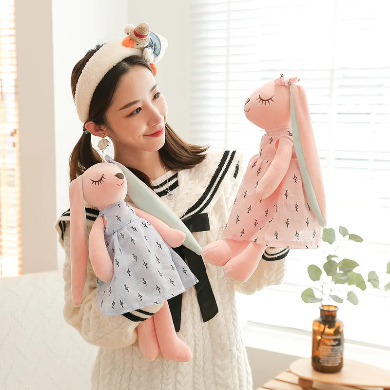 淡いピンクの小枝柄ワンピースを着た眠り目のうさぎぬいぐるみ