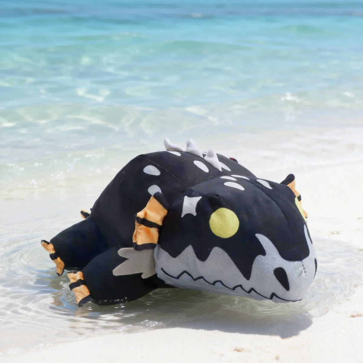 黒い斑点模様のモンスターぬいぐるみ オレンジのヒレと黄色い目