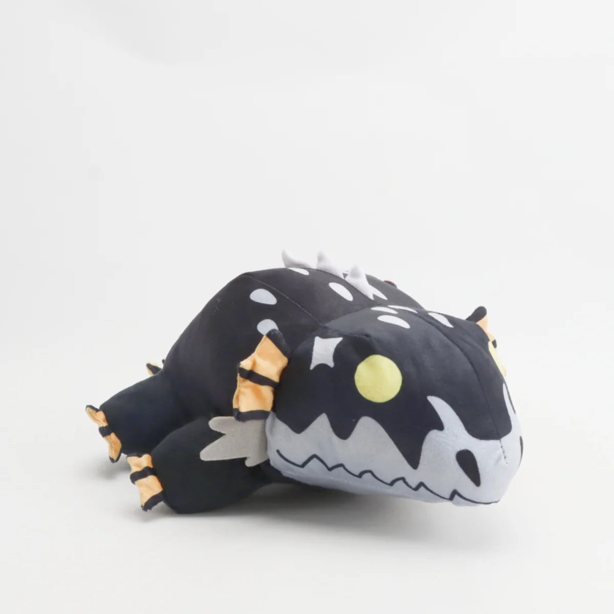黒い斑点模様のモンスターぬいぐるみ オレンジのヒレと黄色い目