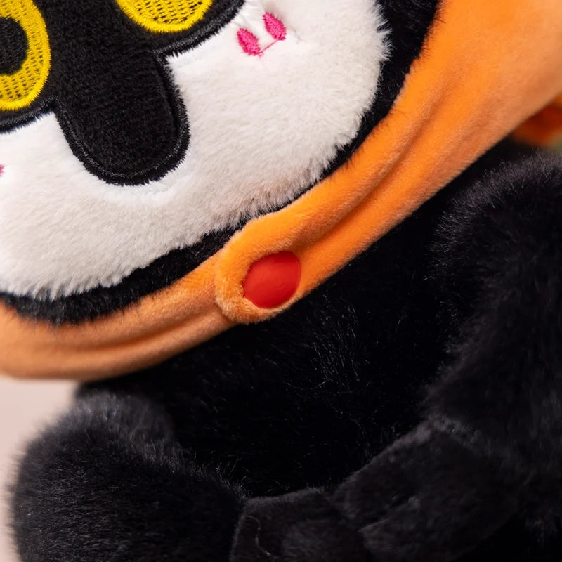 カボチャを被った黄色い目の黒いぬいぐるみ