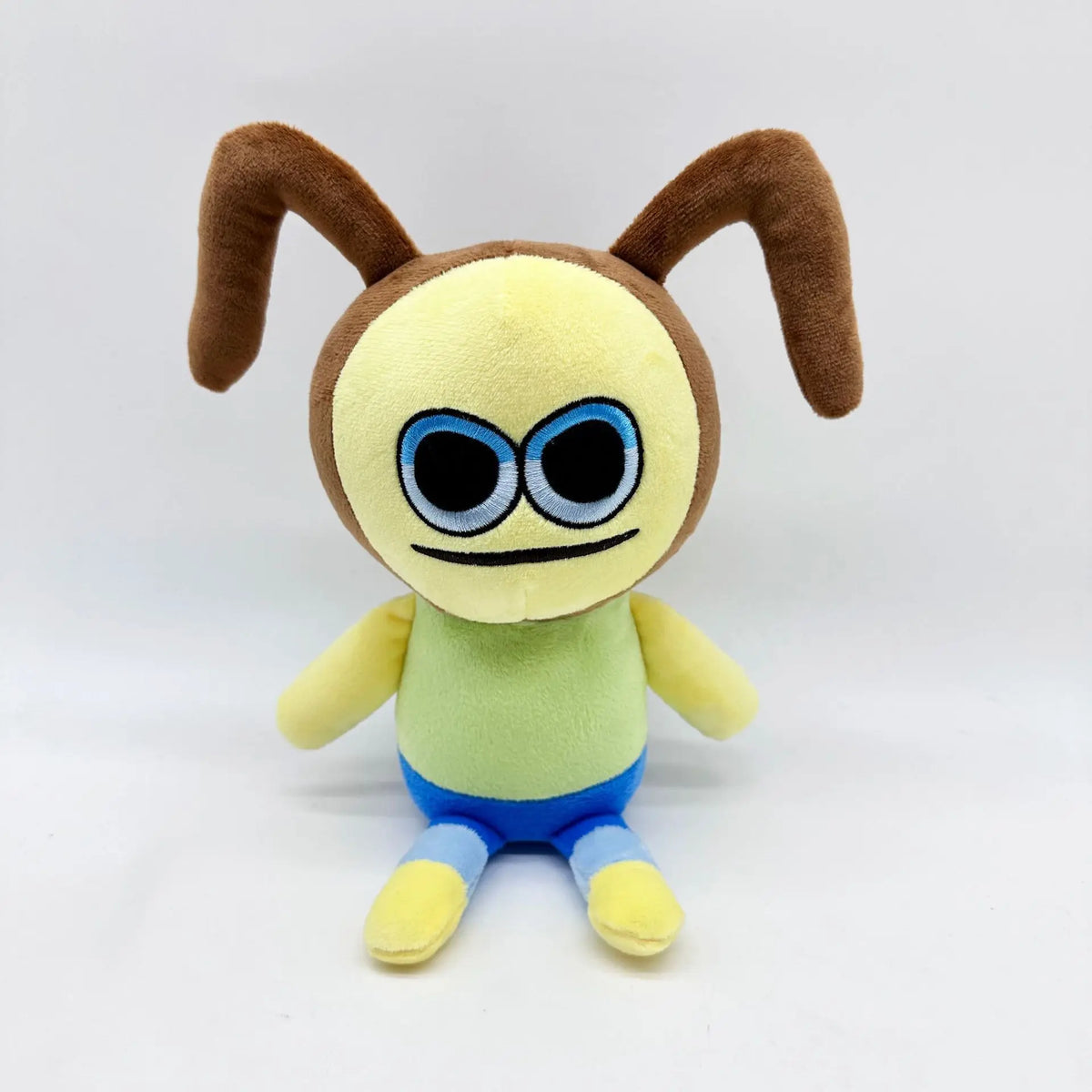黄色い顔と青い目のユニークなキャラクターぬいぐるみ