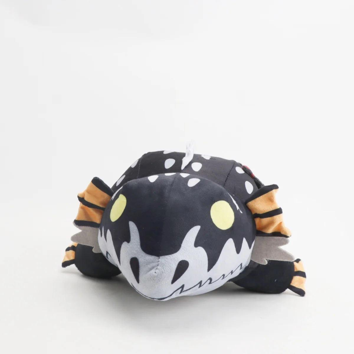 黒い斑点模様のモンスターぬいぐるみ オレンジのヒレと黄色い目